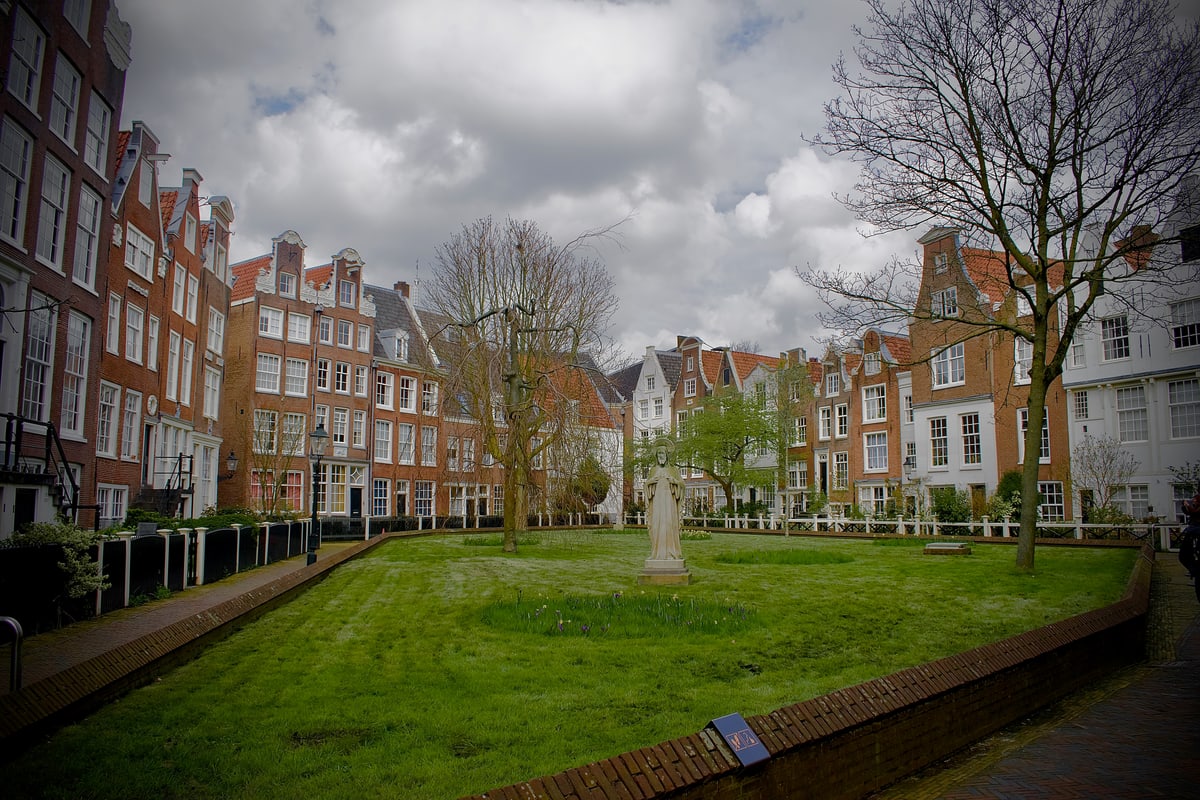 A hidden green courtyard surrounded by old brick houses.