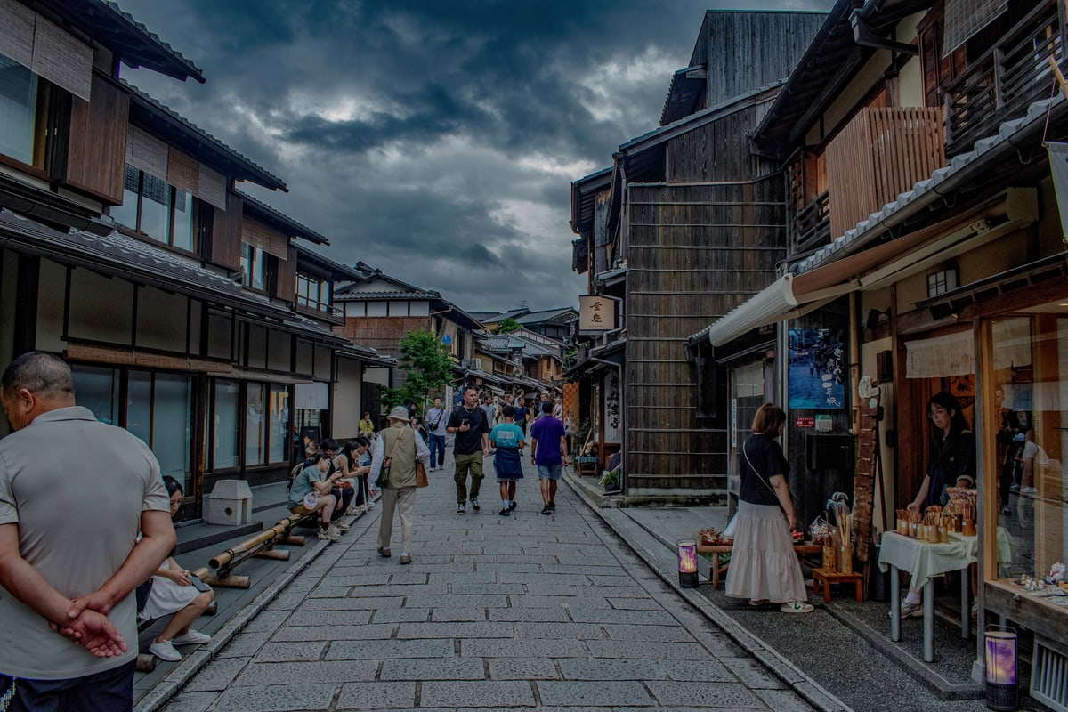 A stone-paved lane lined with traditional wooden shops in Kyoto's old town.