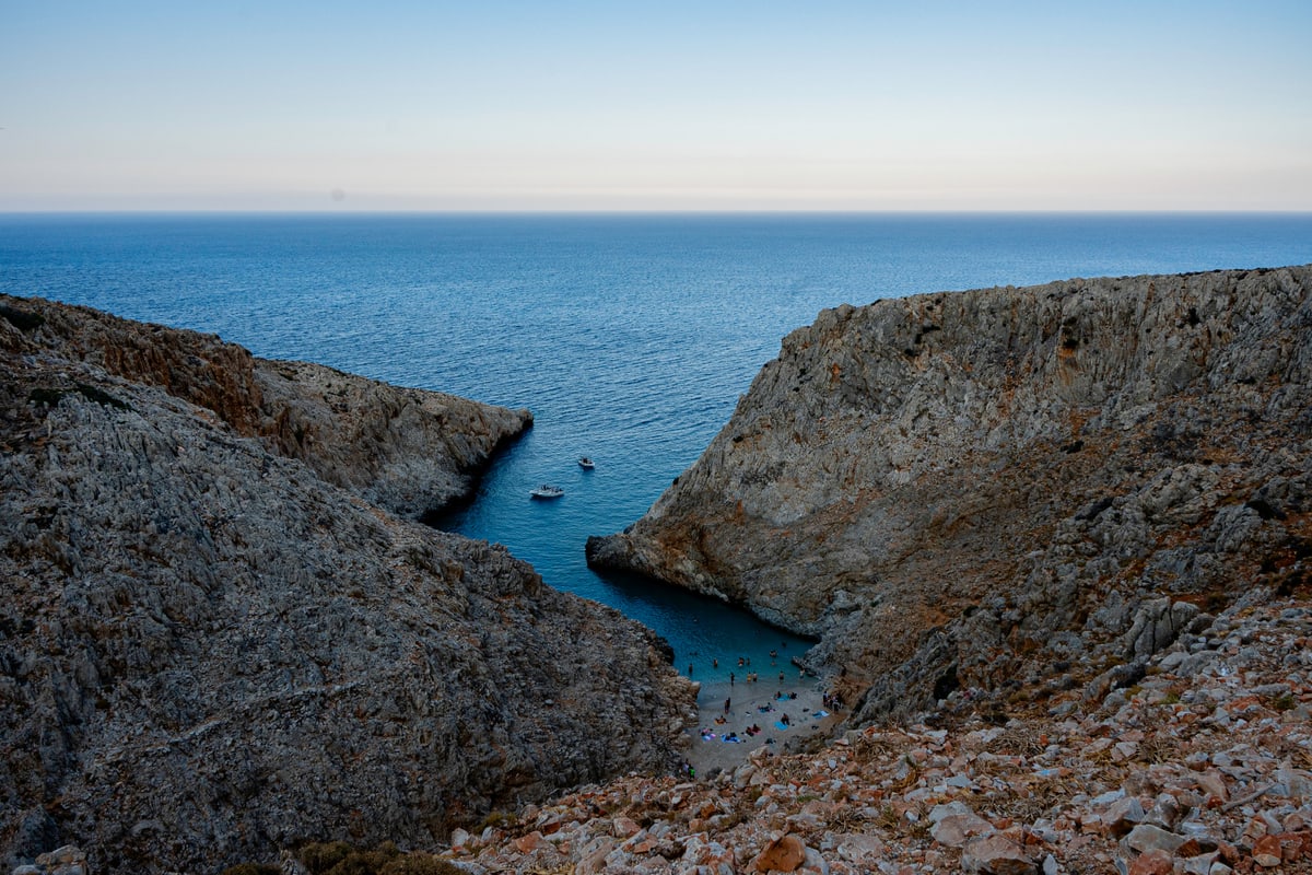 A narrow rocky cove opening onto a calm sea.