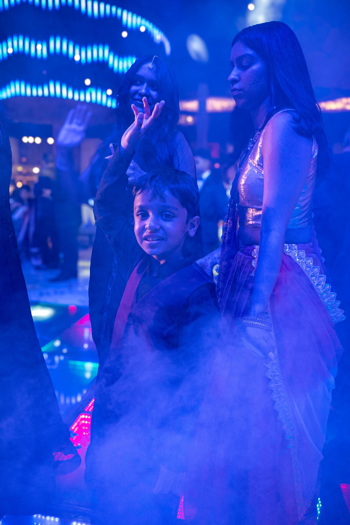 Children dance through stage fog in purple light on the dance floor.